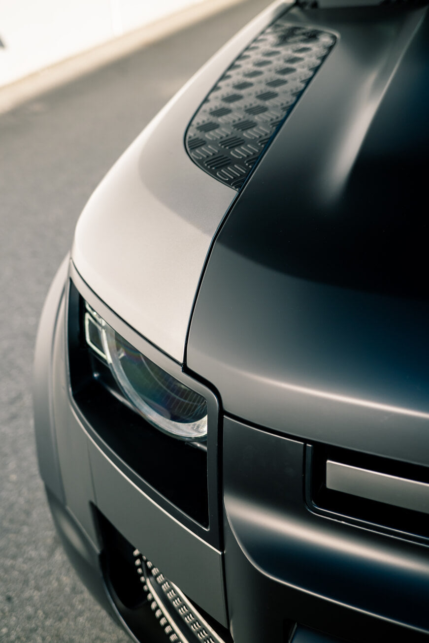 Close-up of the Land Rover Defender's hood protected by AEON Satin Paint Protection Film, illustrating a smooth, textured finish.